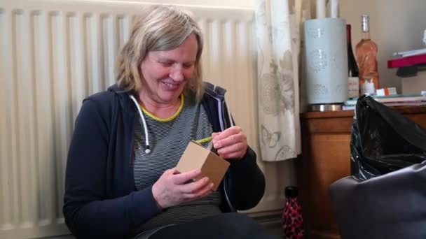 Szczęśliwa Kobieta Siedzi Podłodze Rozpakowuje Prezent Świąteczny — Wideo stockowe