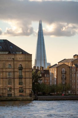 LONDON - November 4, 2020: The Shard seen between old warehouses and modern apartments with the River Thames in the foreground