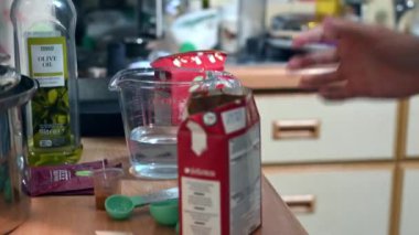 Richmond, North Yorkshire, UK - August 17, 2020: Carton of chopped tomatoes is picked up and added to a hot pan of minced beef and red peppers