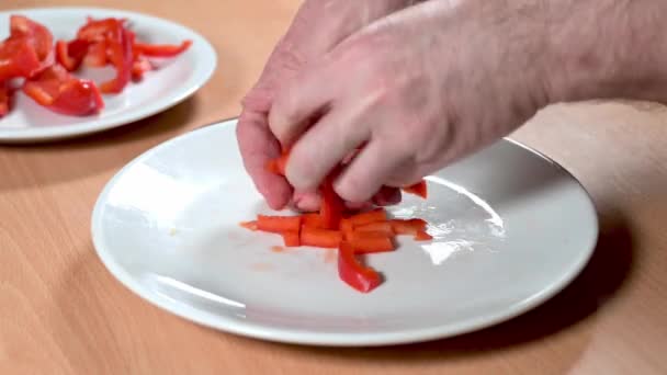 新鲜的红辣椒片由一个人的手从一个盘子移到另一个盘子里 — 图库视频影像