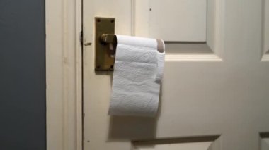 Pirinç kapı kolundan sarkan boş bir tuvalet kağıdı.