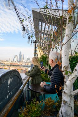 Londra 'yı, OXO Kulesi' nin terasından panoramik manzaranın tadını çıkaran bir kadının gözleriyle görün..