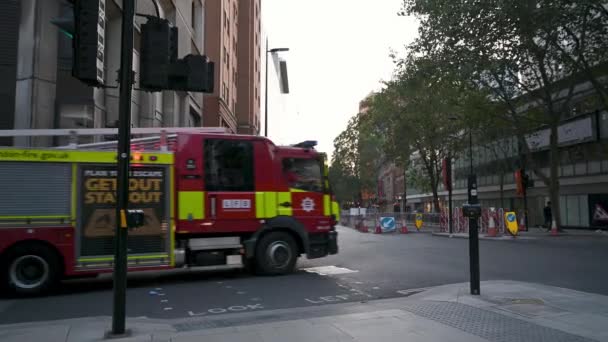 2020年9月12日 一辆伦敦消防队红色消防车在伦敦市中心一个繁忙的十字路口转弯 拥挤的城市的交通和行人都在其中 — 图库视频影像