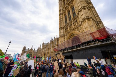 LONDON - 22 Nisan 2023: Parlamento Meydanı 'na doğru yürüyen İsyancı direnişçilerin kararlı enerjilerini keşfedin, bayrakları gururla sallanarak, iklim değişikliğiyle ilgili eylem talep ediyorlar..