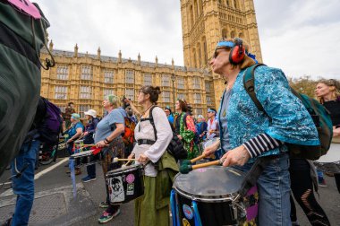 LONDON - 22 Nisan 2023: Tükenme İsyanı protestocuları davul çalıyor, Parlamento Meydanı 'na doğru yürüyorlar, kolektif eylemciliğin güçlü bir gösterisiyle.