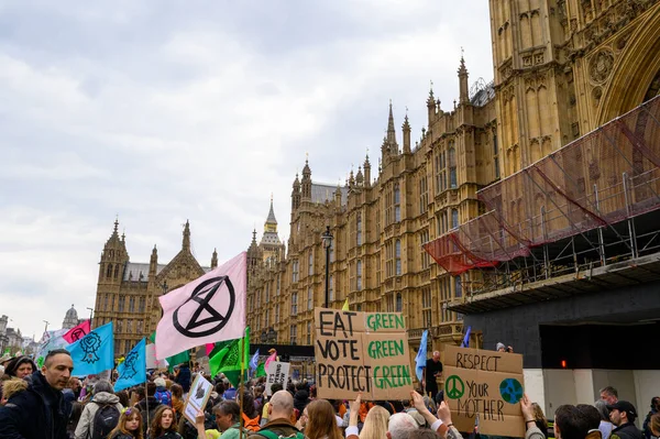 stock image LONDON - April 22, 2023: Join the dynamic activism in motion as Extinction Rebellion protesters make their way towards the Houses of Parliament, their flags waving high in the air.