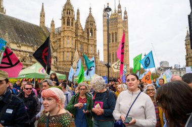 LONDON - 22 Nisan 2023: XR protestosu sırasında parlamentonun önünden geçen, adalet ve yaşanabilir bir gezegen için savaşan protestocuların etkili imajını keşfedin..