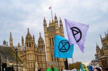 LONDON - 22 Nisan 2023: Londra 'da kolektif çevresel aktivizmin güçlü bir sembolü olan Parlamento Binaları önünde Yok Olma İsyanı bayrakları yükseltildi.