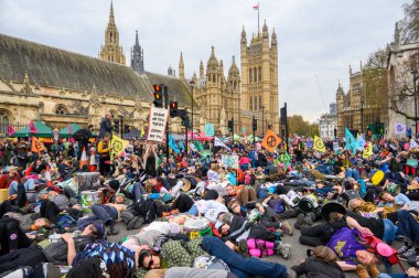 LONDON - 22 Nisan 2023: İklim harekatına duyulan ihtiyacı vurgulamak için, kitlesel bir ölüm eylemine katılan XR protestocularının cesetlerini Meclis 'in önüne koydukları etkili sahneyle ilgilenin..