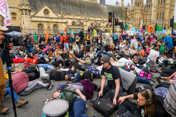 stock image LONDON - April 22, 2023: Witness the powerful Extinction Rebellion mass die-in as protesters lie down before the Houses of Parliament, demanding urgent climate action and environmental justice.