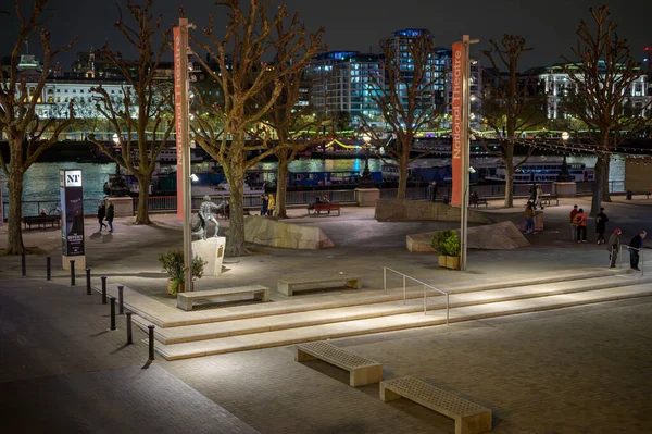 LONDON - 22 Nisan 2023: Ulusal Tiyatro 'nun gece parıltısı, Southbank' in cazibesini tanımlayan sakin Thames Nehri ile buluşur..