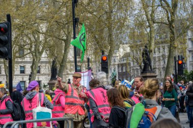 LONDON - 22 Nisan 2023: Londra 'nın güvenlik ekibi: Yüksek görüş mesafesi olan hostesler, XR protesto yürüyüşünde düzen ve güvenliğin sağlanmasında hayati rol oynuyor.