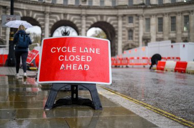 LONDON - 24 Nisan 2023: Kırmızı bisiklet şeridi kapalı levha yağmurlu bir günde Amirallik Kemeri 'nin yol çalışması yapacağı uyarısında bulundu.