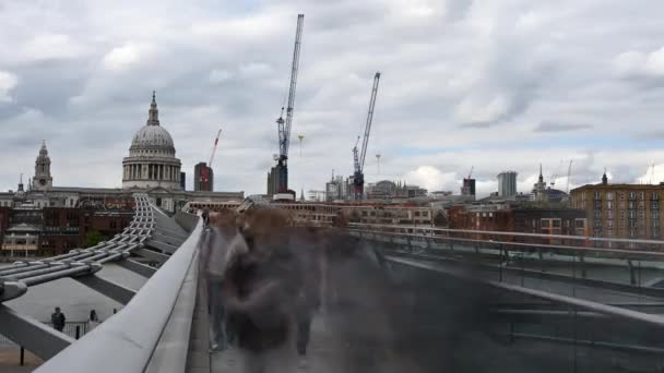 2023년 상징적인 대성당과 크레인으로 구성된 런던의 밀레니엄 브릿지 건너편에 사람들의 — 비디오