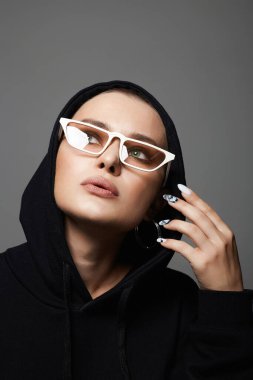 beautiful young woman wearing Hoodie and fashionable glasses. stylish bald girl in Hood