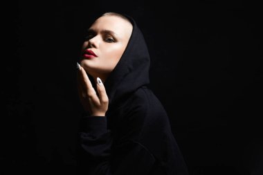 young woman with short haircut in Hood. stylish bald girl in Dark
