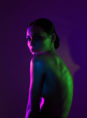 beauty young woman in color lights. beautiful naked girl with make-up and shining Body