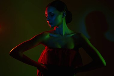 Renkli parlak ışıklar içinde güzel bir kadın. Kırmızı elbiseli güzel kızın silueti.