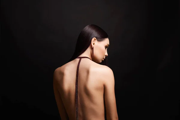 beautiful young woman with necklace on her naked back. Nude Girl with jewelry