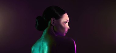 female back. beauty young woman in green and purple color lights. beautiful naked girl with shining Body