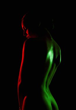 beautiful naked woman in color lights. Silhouette of girl with radiance body