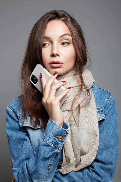 beautiful young woman with cellphone, communicating online. portrait of girl in scarf