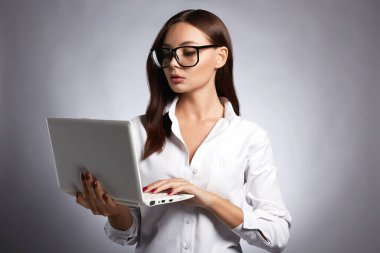 Gözlüklü güzel bir iş kadını. Dizüstü bilgisayarı olan güzel kız. Öğrenci 