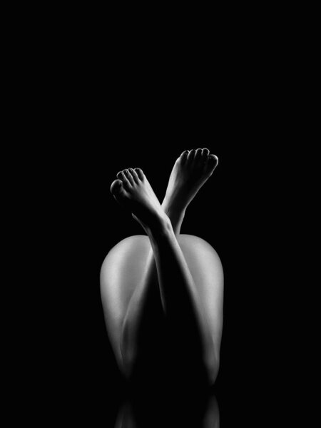 Female beautiful Naked legs. girl body silhouette in the dark. Black and white poster