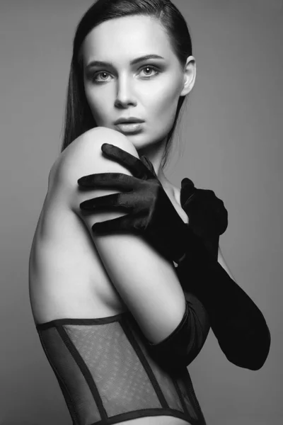 Brunette Girl in gloves and underwear. Black and white portrait of sexy Beautiful young Woman