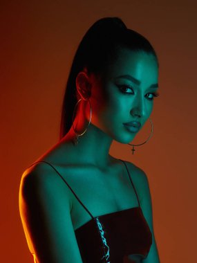Renkli ışıklar içinde güzel bir genç kadın. Esmer kız stüdyo resmi