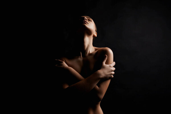 Elegant Nude Woman silhouette in the dark. Beautiful Naked Body Girl