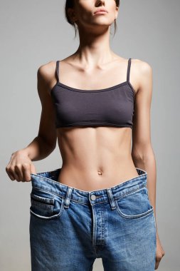 Kot pantolonlu genç kadını zayıflatıyor. Belden aşağısı. Güzel vücut Sıska Kız