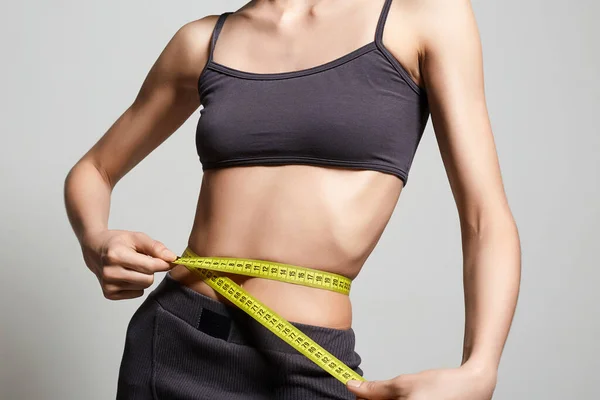 Young woman measuring her thin waist. Beautiful body Thin Girl