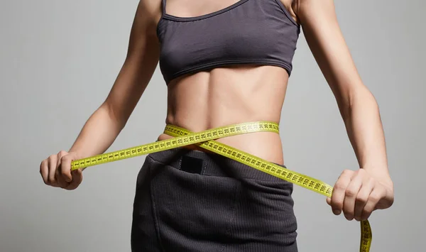 Young woman measuring her thin waist. Beautiful body Thin Girl