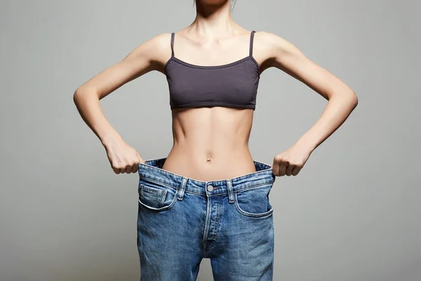 slimming Young woman in jeans. low waist. Beautiful Thin body Girl. Studio portrait