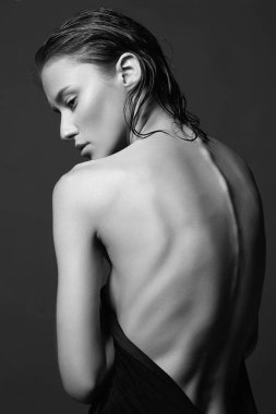 Çıplak kadın geri döndü. Havlu giymiş genç ve ıslak bir kadın. Duştan sonra ıslak saçlı güzel seksi kız. Siyah beyaz portre.