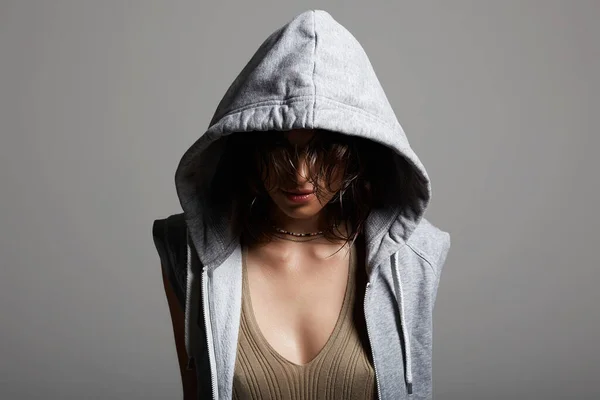 young woman in hood. person with head covered. sexy girl in grey hoodie