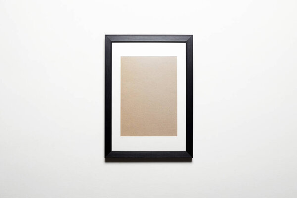 Black picture frame on a wall. Stylish photoframe for poster or pictute. Empty frame for mock up, with white passepartout, standing portait mode