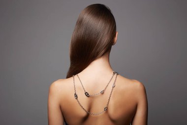 Sırtında kolyesi olan genç ve güzel bir kadın. Mücevherleri olan seksi kız