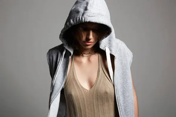 young woman in hood. person with head covered. sexy girl in grey hoodie