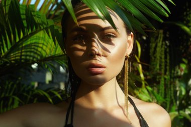 Güzel yaz kızı. Palmiye ağacının altında bikinili seksi bir kadın. Güzellik Portresi