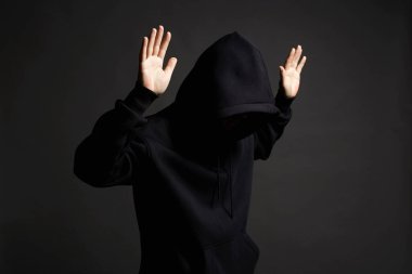 Siyah Başlıklı Çocuk. Kapüşonlu adam teslim oluyor. Tutuklanmak için ellerini kaldırıyor. İnsan hakları