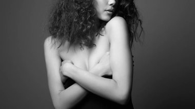 Kıvırcık saçlı, güzel, seksi genç bir kadın. Güzel bir kızın siyah beyaz portresi.