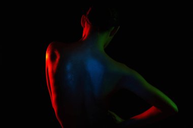 Dişi geri döndü. Renkli parlak ışıklar altında çıplak kadın. Güzel çıplak kız silueti