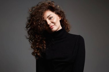 Kıvırcık saçlı, gülümseyen güzel bir kadın. Güzel kıllı kızın güzel portresi.