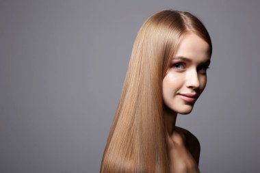 Güzel sarışın genç kadın. Sağlıklı saçlı, gülümseyen kız.