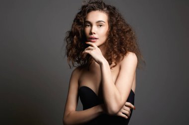 Kıvırcık saçlı güzel bir genç kadın. Güzel bir kızın güzel portresi.