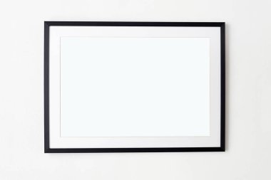 Beyaz duvar zemininde boş bir çerçeve. Poster ya da resim için modası geçmiş bir fotofram. Model için boş çerçeveler