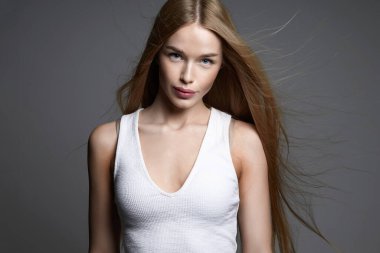 Güzel sarışın genç kadın. Güzel gülümseyen bir kızın güzel portresi, sağlıklı uçan saçlarıyla.