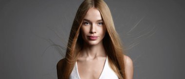 beautiful blond young woman with Healthy flying Hair. beauty portrait of hairy pretty smiling girl 